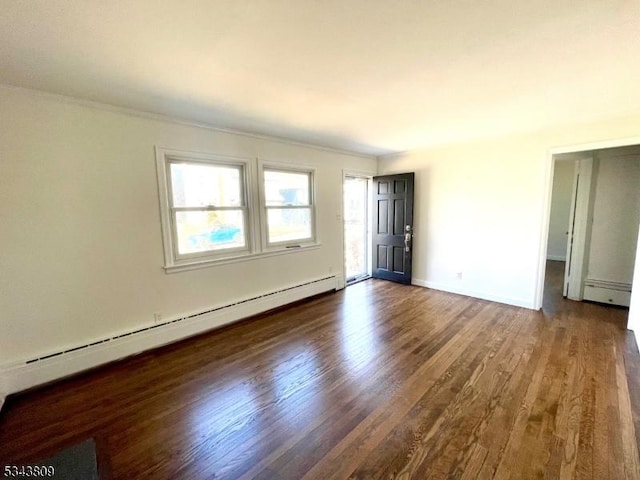 empty room featuring a baseboard radiator, baseboards, and dark wood finished floors