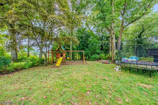 view of yard with a playground and a trampoline