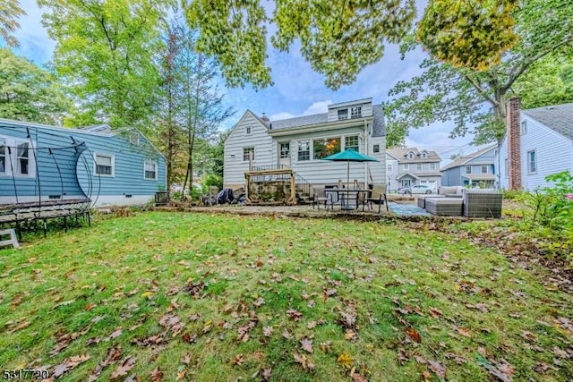 back of property featuring a yard, a patio, a trampoline, and outdoor lounge area