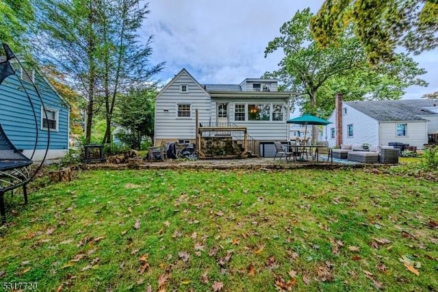 back of property featuring an outdoor living space, a patio, and a yard