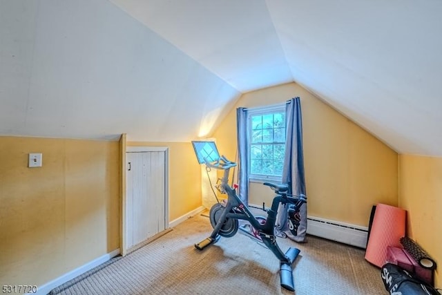 exercise room with baseboards, carpet floors, baseboard heating, and vaulted ceiling