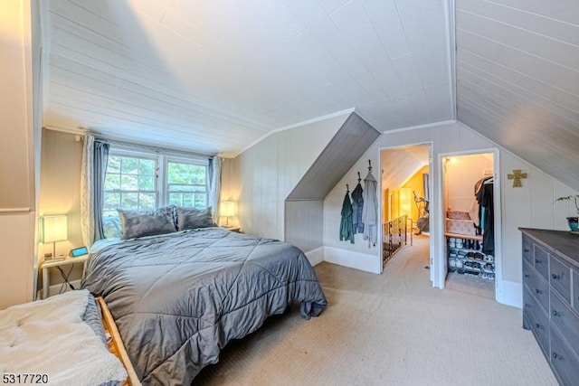 bedroom featuring lofted ceiling, a spacious closet, and light carpet