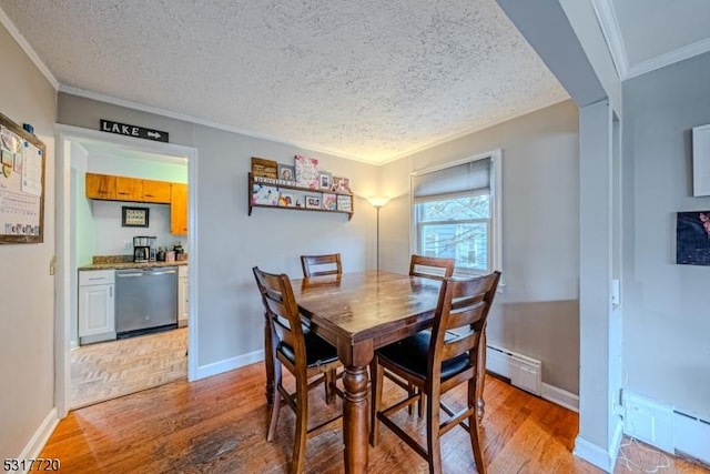 dining room featuring a textured ceiling, crown molding, light wood-style floors, and a baseboard radiator