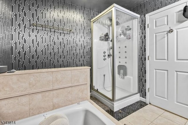 full bath with tile patterned flooring, a shower stall, wallpapered walls, and a bath