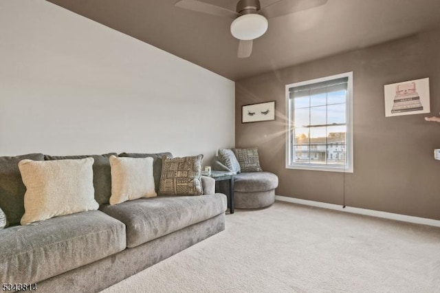 carpeted living area featuring baseboards and ceiling fan