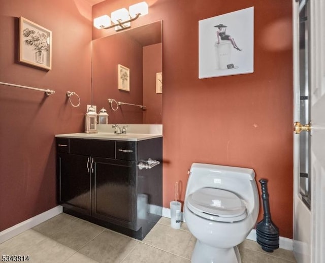 half bathroom featuring tile patterned flooring, toilet, vanity, and baseboards