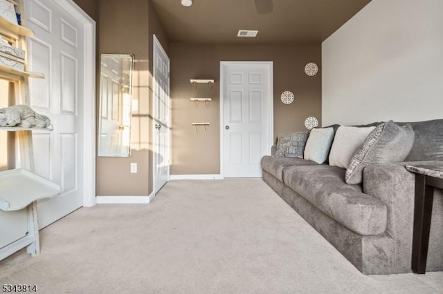 living area featuring a ceiling fan, carpet flooring, baseboards, and visible vents