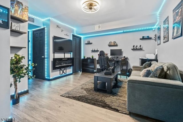 living area featuring visible vents and wood finished floors