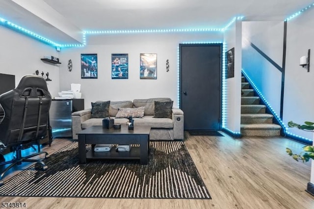 living area featuring stairway and wood finished floors