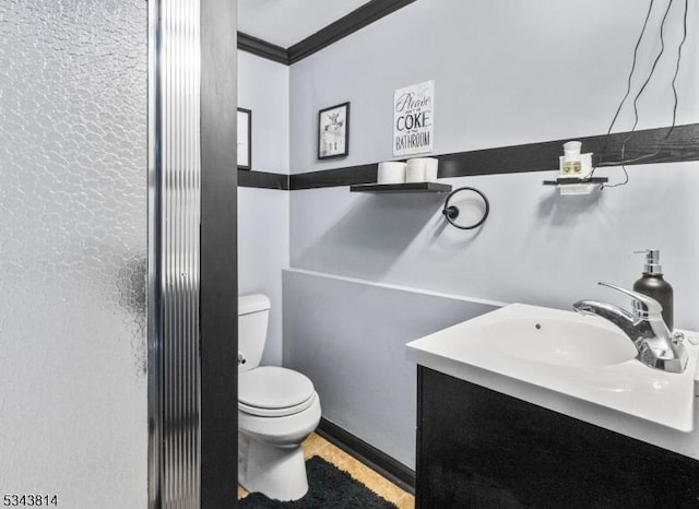 bathroom with vanity, crown molding, and toilet