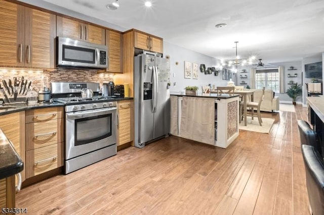 kitchen featuring light wood-style flooring, backsplash, dark countertops, appliances with stainless steel finishes, and brown cabinetry