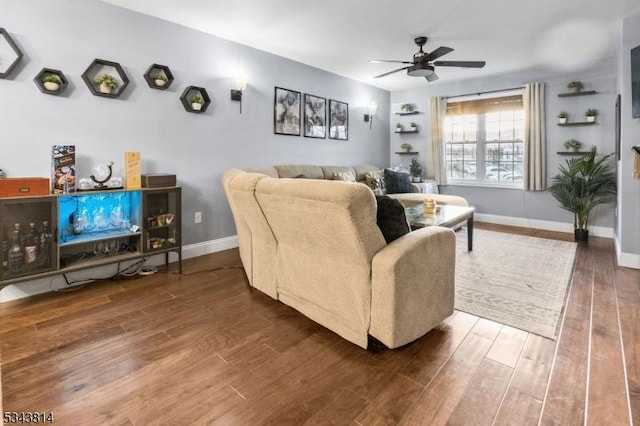 living room featuring wood finished floors, a ceiling fan, and baseboards