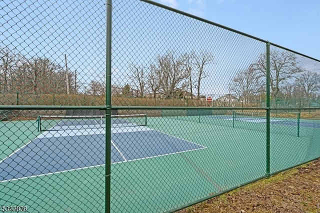 view of tennis court featuring fence