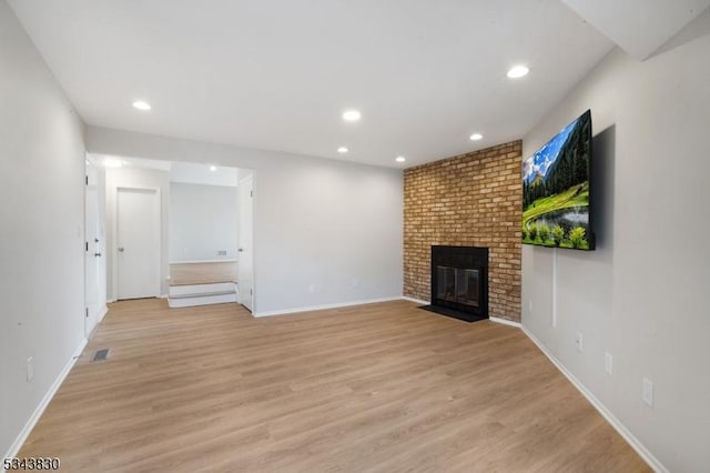 unfurnished living room featuring recessed lighting, light wood-style floors, and a fireplace