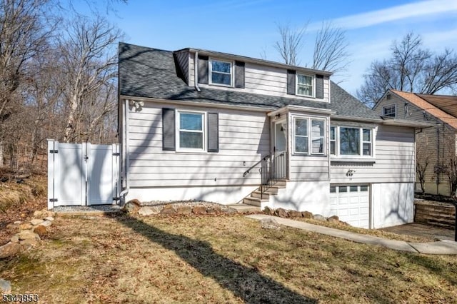 view of front of property featuring a gate, entry steps, a garage, and roof with shingles