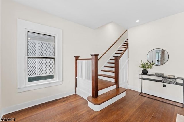 staircase with recessed lighting, wood finished floors, and baseboards