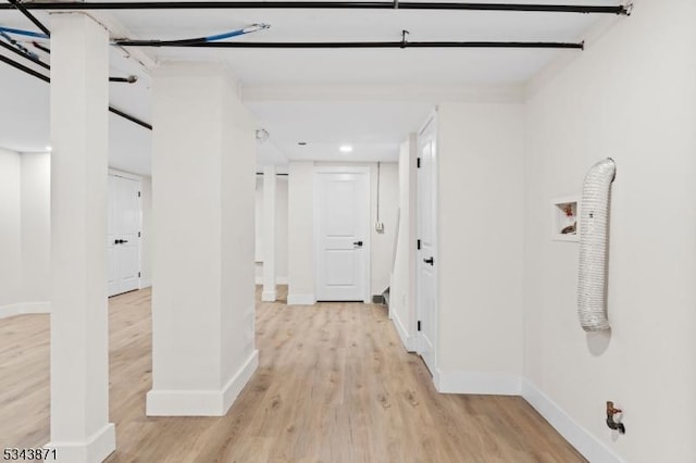 hall with baseboards and light wood finished floors