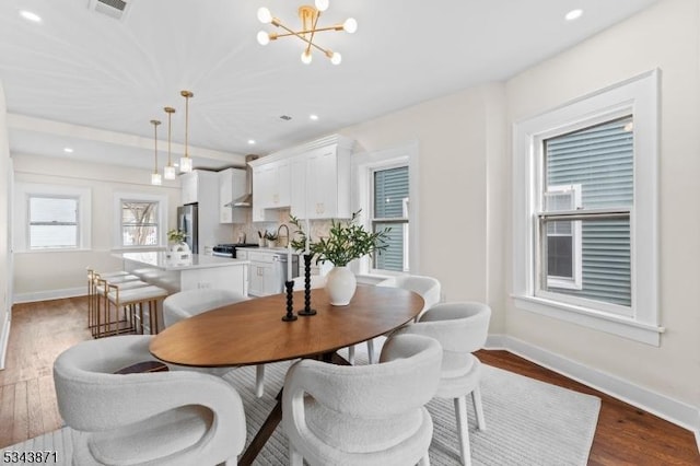 dining room with dark wood-style floors, a chandelier, recessed lighting, and baseboards