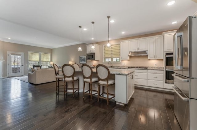 kitchen featuring white cabinetry, appliances with stainless steel finishes, under cabinet range hood, and a healthy amount of sunlight