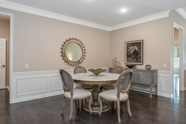 dining room with dark wood-type flooring, a decorative wall, wainscoting, and ornamental molding