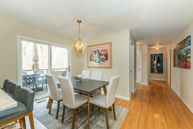 dining space with light wood-style floors, baseboards, a notable chandelier, and visible vents