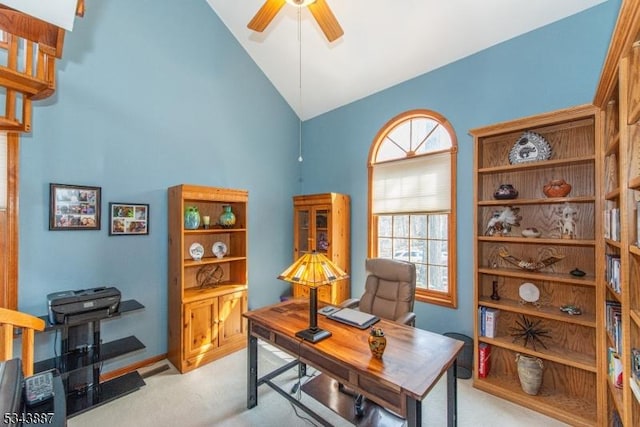 office space with a ceiling fan, lofted ceiling, and light colored carpet