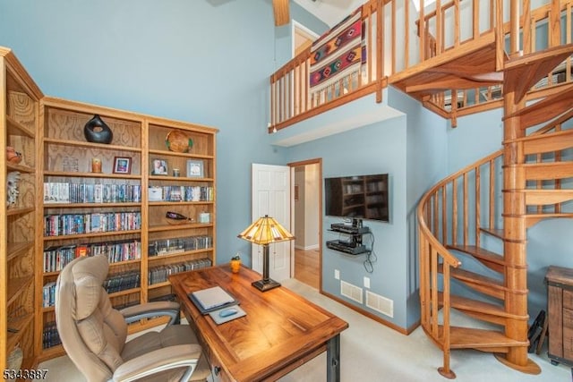 office featuring baseboards, a high ceiling, and carpet