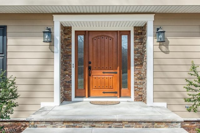 doorway to property featuring stone siding