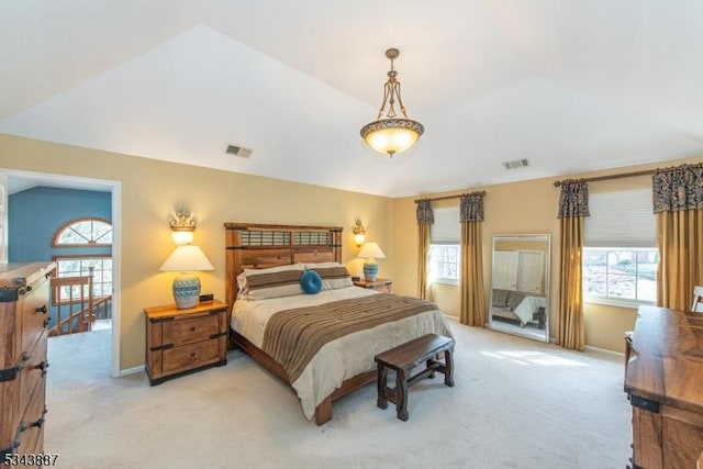 bedroom with light carpet, visible vents, and lofted ceiling