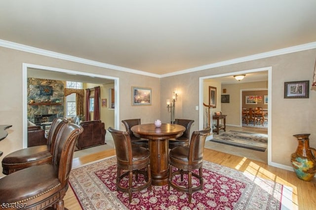 dining room featuring baseboards, light wood-style floors, and crown molding