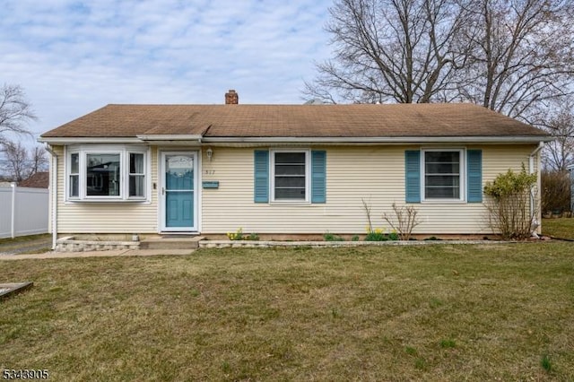 view of front of house with a front yard, fence, and a chimney