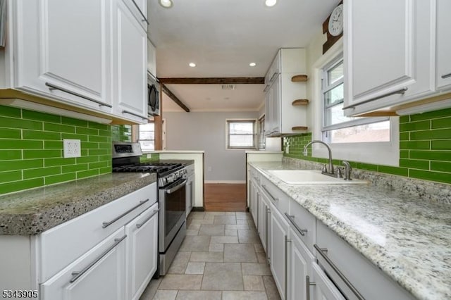 kitchen with baseboards, recessed lighting, a sink, stainless steel appliances, and white cabinets