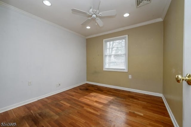 empty room with a ceiling fan, wood finished floors, baseboards, visible vents, and ornamental molding