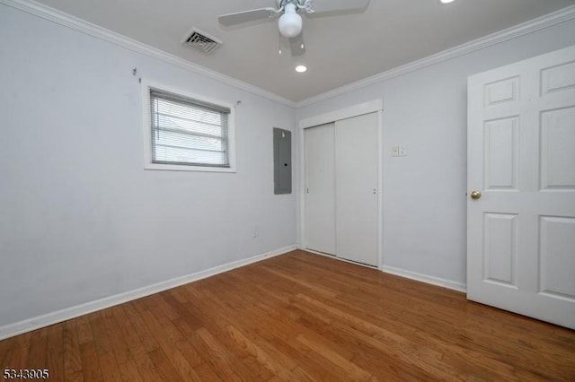 unfurnished bedroom featuring visible vents, wood finished floors, baseboards, and ornamental molding