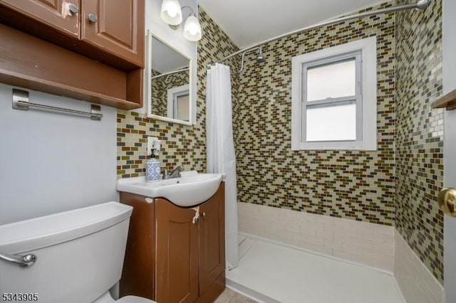 bathroom with vanity, backsplash, toilet, and a tile shower