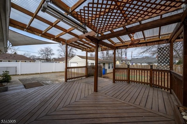 wooden terrace with an outdoor structure and a fenced backyard