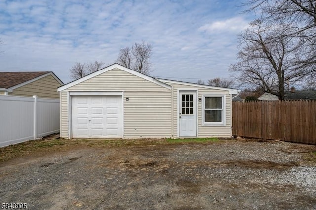 detached garage featuring fence