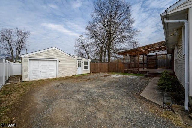 view of yard featuring a garage, driveway, a deck, and fence