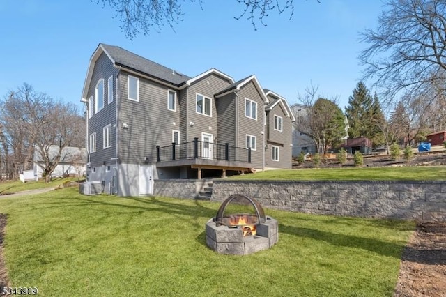 back of house with a deck, a yard, central AC unit, and an outdoor fire pit