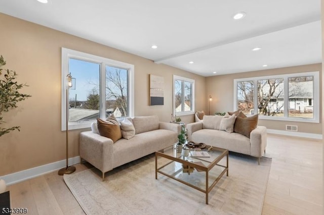 living area with recessed lighting, visible vents, baseboards, and light wood finished floors