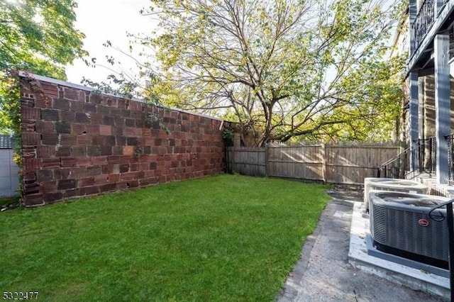 view of yard with central AC unit and a fenced backyard