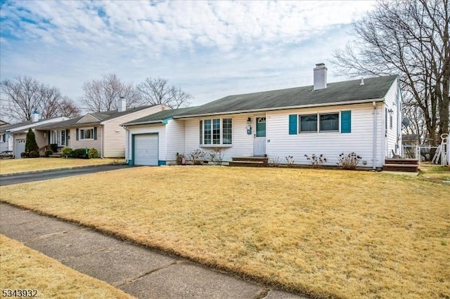 ranch-style home featuring driveway, a front lawn, a chimney, and an attached garage