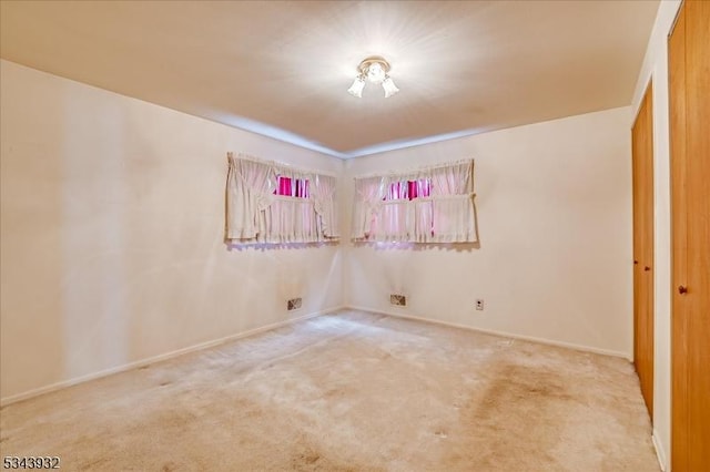 carpeted spare room featuring baseboards