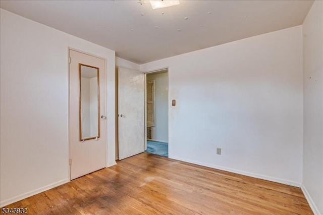 unfurnished room with baseboards and light wood-style flooring