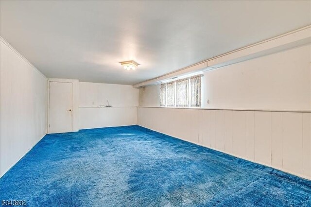 empty room featuring wainscoting and carpet floors