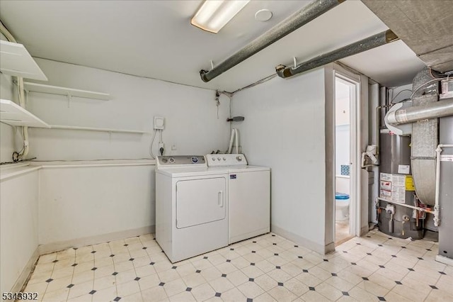 washroom featuring water heater, washing machine and dryer, and light floors