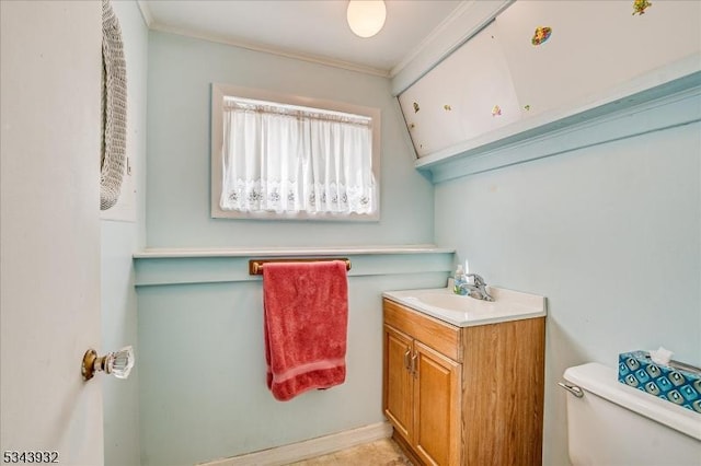 bathroom with vanity, toilet, and ornamental molding