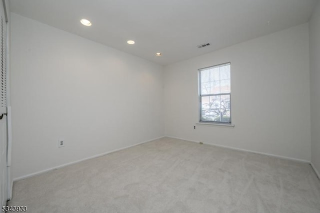 empty room featuring baseboards, recessed lighting, visible vents, and light carpet