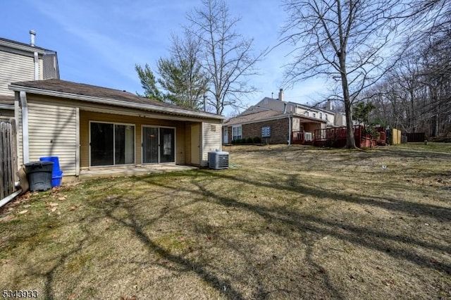 rear view of house with a yard and central AC unit