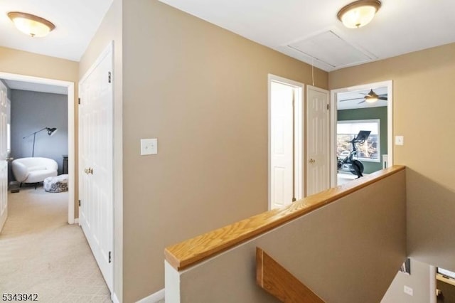 hallway with baseboards, an upstairs landing, light colored carpet, and attic access